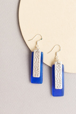 Telina rectangular drop earrings in blue with a sea glass texture and silver hammered rectangular accent layered on top handmade by people with disabilities